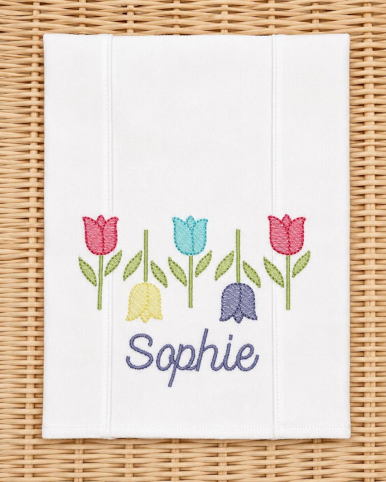 White burp cloth embroidered with five tulips and the name Sophie