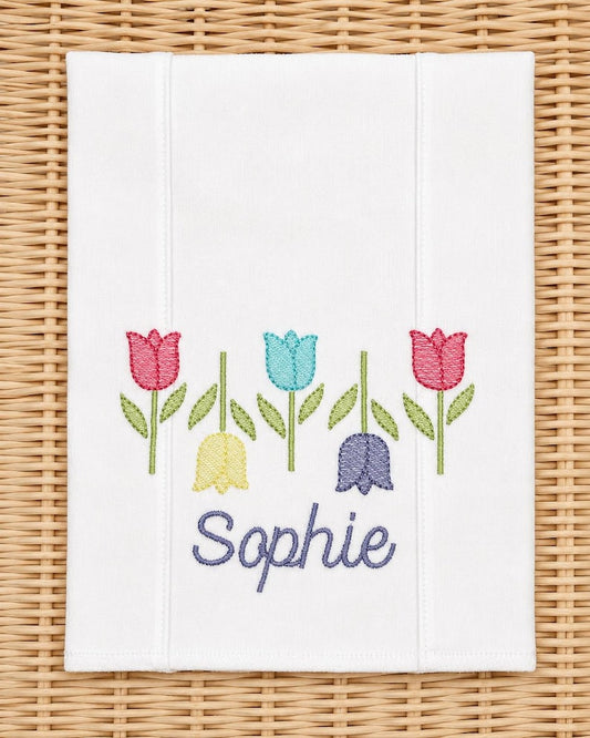 White burp cloth embroidered with five tulips and the name Sophie