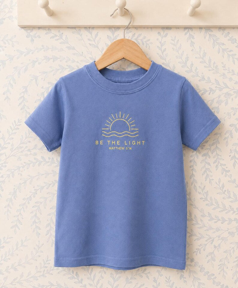 Periwinkle tee with yellow embroidered sunrise, Be the Light and Matthew 5:14