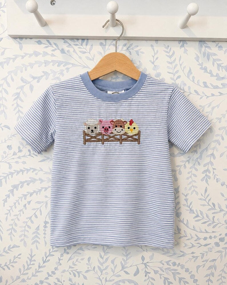 Close view of the embroidered sheep, pig, cow and chicken design